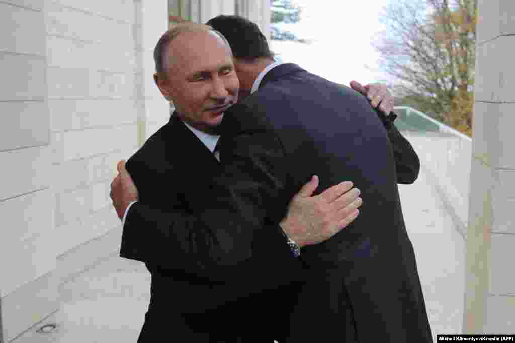 Russian President Vladimir Putin (left) and his ally, Syrian President Bashar al-Assad, embrace during a meeting in Sochi on November 20. (AFP/Mikhail Klimentyev)