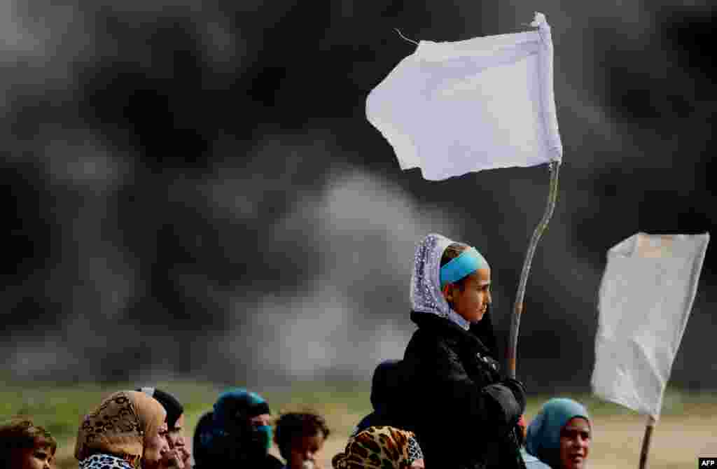 Girls hold makeshift white flags as they flee with their families during a military operation by Iraqi security personnel in the desert west of the city of Samarra aimed at retaking areas from Islamic State group jihadists. (AFP/Ahmad Al-Rubaye)