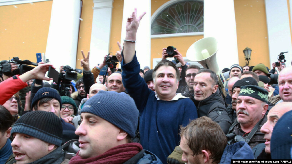 Саакашвили өзін СБУ шағын автобусынан босатып алған жақтастарының ортасында тұр.