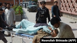 Afghan volunteers carry an injured man on a stretcher to a hospital following a bomb blast in Jalalabad on March 19.