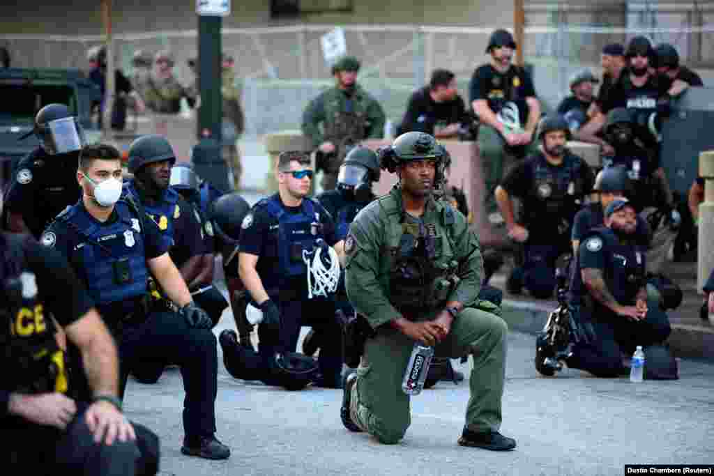 Officers kneel with protesters during a protest against the death in Minneapolis in police custody of African-American man George Floyd, in Downtown Atlanta, Georgia, June 1, 2020