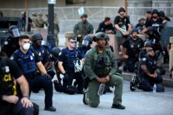 Policët në Xhorxhia të ulur në gjunjë gjatë një proteste pas vdekjes së afrikano-amerikanit George Floyd.