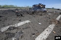 Місце боїв і згорілий бронеавтомобіль поблизу Луганського аеропорту у липні 2014 року
