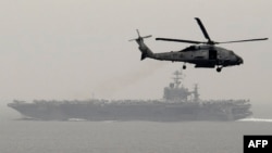 در این تصویر ناو هواپیمابر ترومن و یک هلیکوپتر آمرکایی در مدیترانه دیده می‌شود