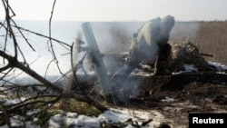 A Ukrainian soldier fires a mortar toward Russian troops at a frontline position near Vuhledar on February 11.