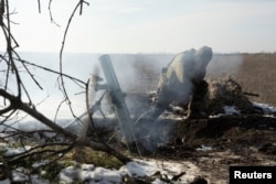 Egy ukrán katona aknavetőgránátot lő ki az orosz csapatok felé egy frontállásnál Vuhledar közelében február 11-én