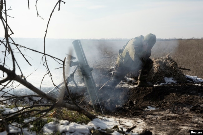 A Ukrainian soldier fires a mortar shell toward Russian troops at a frontline position near Vuhledar on February 11.