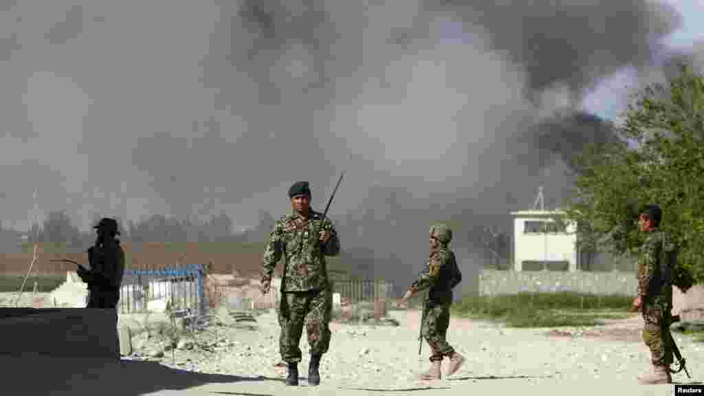 Soldiers from the Afghan National Army keep watch near a Provincial Reconstruction Team as smoke rises from the site of an attack in Jalalabad Province on April 15. (REUTERS/Parwiz)