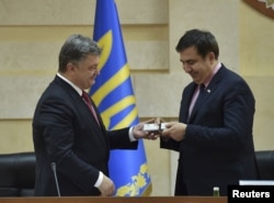 Petro Poroșenko oferindu-i lui Mihail Saakașvili cartea de identitate ucraineană în 2015.