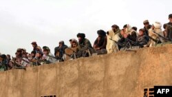 Afghan Taliban fighters listen to Mullah Mohammad Rasool Akhund (unseen), the newly appointed leader of a breakaway faction of the Taliban, at Bakwah in the western province of Farah in November 3.