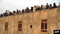 Afghan Taliban fighters listen to Mullah Mohammad Rasul Akhund (unseen), the newly appointed leader of a breakaway faction of the Taliban, at Bakwah in the western province of Farah on November 3.