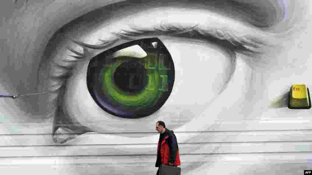 A man walks by a wall adorned with graffiti in Athens. (AFP/Louisa Gouliamaki)