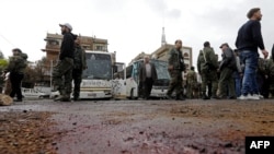 Syrian security forces and locals gather at the scene of a bombing following twin attacks targeting Shi'a pilgrims in Damascus's Old City on March 11. 