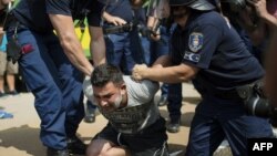 Угорська поліція арештовує мігранта, 3 вересня 2015 року