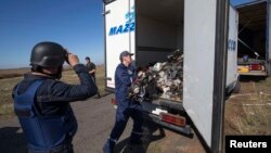 A Ukrainian Emergency Situations Ministry worker loads items recovered at the site where the downed Malaysia Airlines Flight 17 crashed, near the village of Hrabove in the Donetsk region, on October 13.