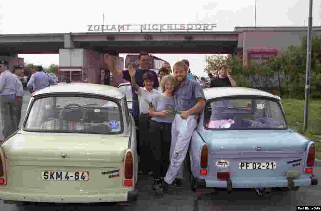 East Germans refugees smile next to their Trabants after crossing into Nickelsdorf, Austria.