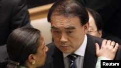 China's Ambassador to the UN, Li Baodong, speaks with U.S. envoy Susan Rice at a Security Council meeting on March 17.