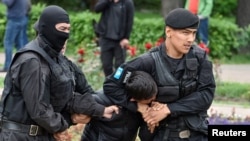 Сотрудники спецназа задерживают человека на месте протестной акции в Алматы против президентских выборов. 9 июня 2019 года