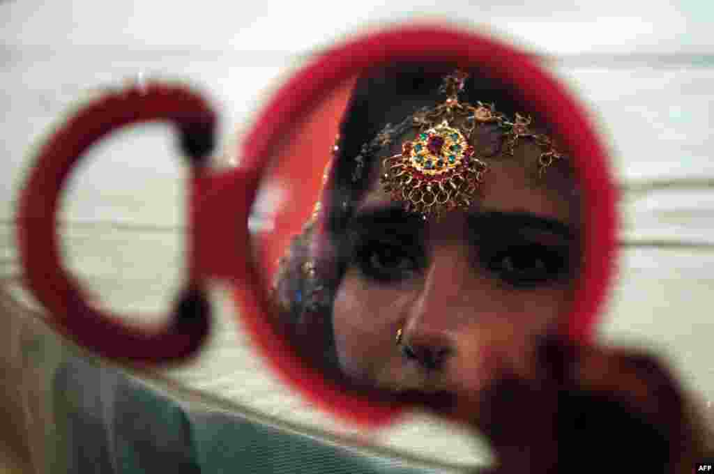  A Pakistani bride looks in a mirror as she attends a mass wedding ceremony in Karachi. (AFP/Asif Hassan)