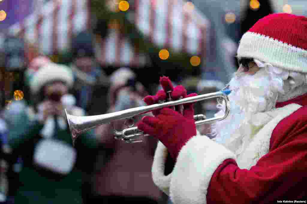 Një burrë me kostum Babadimri duke i rënë borisë para ngjarjes bamirëse &quot;Santa Fun Run&quot; në Riga, Letoni, 8 dhjetor 2024.