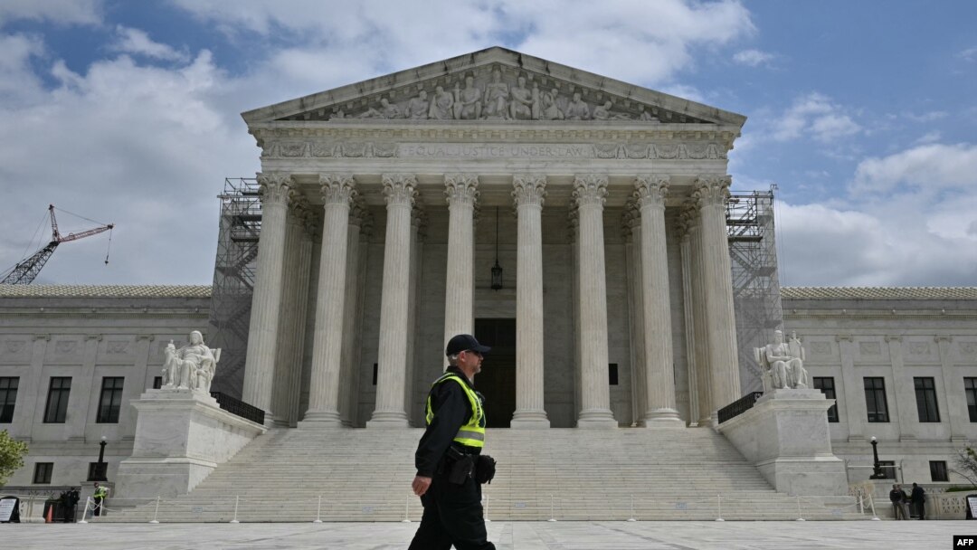 Un ofițer de poliție se plimbă în piața Curții Supreme a SUA în timp ce tribunalul audiază argumente privind imunitatea fostului președinte american Donald Trump, pe 25 aprilie 2024, la Washington, DC.