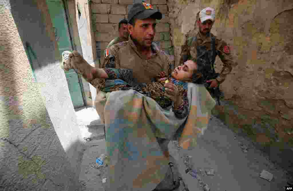 A member of the Iraqi Counterterrorism Service carries a wounded girl in the Old City of Mosul on July 3 during an ongoing offensive to retake the city from Islamic State extremists. Iraqi forces have been closing in on the Old City in western Mosul for months, but the terrain, combined with a large civilian population, has made for an extremely difficult fight. (AFP/Ahmad al-Rubaye)