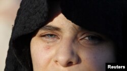 A Syrian woman living in Jordan, with her lips painted in the colors of the Syrian national flag, attends a demonstration against Syria's President Bashar al-Assad in front of the Syrian Embassy in Amman on May 15.