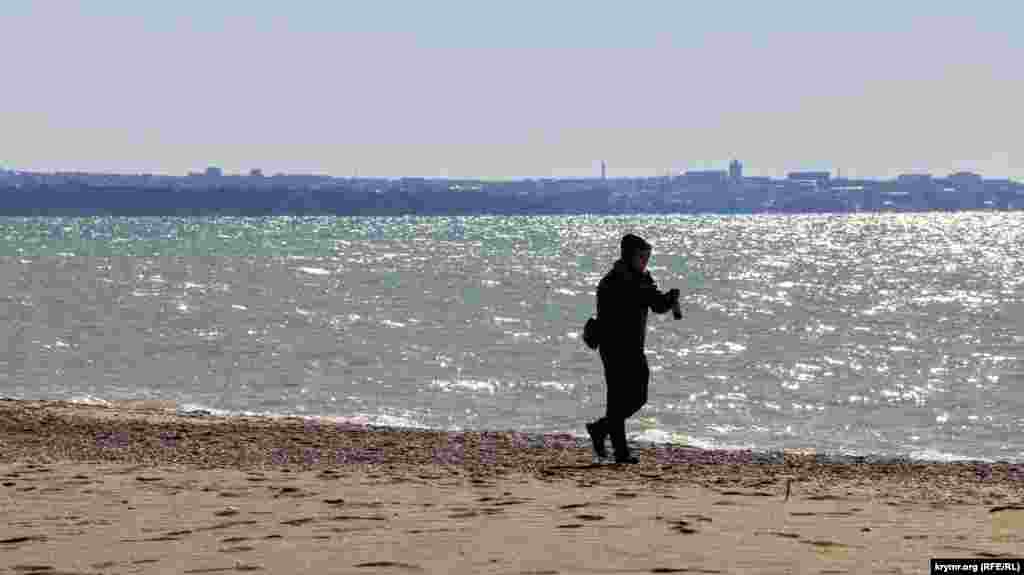 Одинокий мужчина прогуливается по пляжу