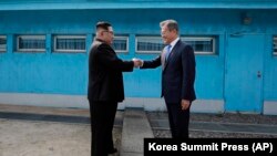 North Korean leader Kim Jong Un (left) shakes hands with South Korean President Moon Jae-in at the border village of Panmunjom in the demilitarized zone on April 27.