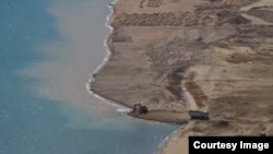 Ысык-Көлгө кум төгүп жаткан унаалар. Арель, 2026-жыл. (Эртай Исаковдун баракчасындагы тасмадан)