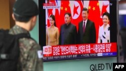 Оңтүстік Корея сарбазы теледидардан Солтүстік Корея басшысы Ким Чен Ынның Қытай төрағасы Си Цзиньпинмен кездесуі жайлы хабарды көріп тұр. Сеул, 28 наурыз 2018 жыл.