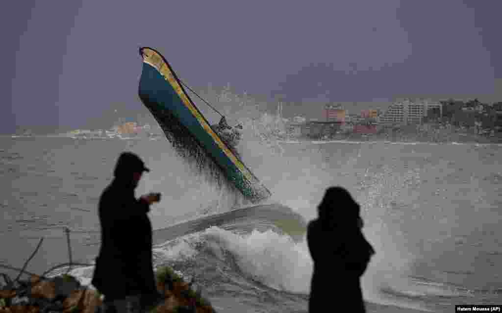 Palestinian fishermen ride their boat amid high waves on a windy and rainy day at the sea in Gaza City.&nbsp;&nbsp;(AP/Hatem Moussa)&nbsp;