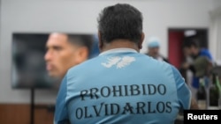 Un veteran argentinian urmărind meciul Argentina-Anglia. Mesajul de pe spate: „Interzis să-i uităm”, într-o referință la soldații căzuți.