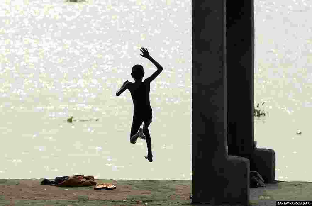 An Indian youth leaps into the flooded Ganges River in the Jushi area of Allahabad. (AFP/Sanjay Kanojia)