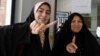 Iranian women display their ink-stained fingers after casting their ballot for the second round of parliamentary elections at a polling station in Robat Karim, some 40 kilometers southwest of the capital, Tehran.