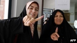 Iranian women display their ink-stained fingers after casting their ballot for the second round of parliamentary elections at a polling station in Robat Karim, some 40 kilometers southwest of the capital, Tehran.