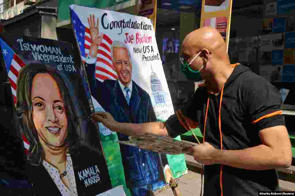 На дорозі у Мумбаї художник завершує роботу над портретом Камали Гарріс. Поруч стоїть уже готовий портрет переможця виборів президента Сполучених Штатів Джо Байдена