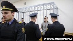 Суд супраць анархістаў, 12 лютага. За кратамі зьлева Іван Комар, справа Мікіта Емяльянаў