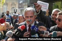 Протестувальник тримає наручники перед обличчям лідера Соціал-демократичної партії Румунії Лівіу Драгнеа, 3 жовтня 2017 року