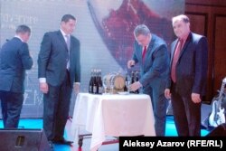 Вице-мэр Канн Франк Чикли (cлева) смотрит, как разливают вино «Божоле нуво». Алматы, 21 ноября 2014 года.