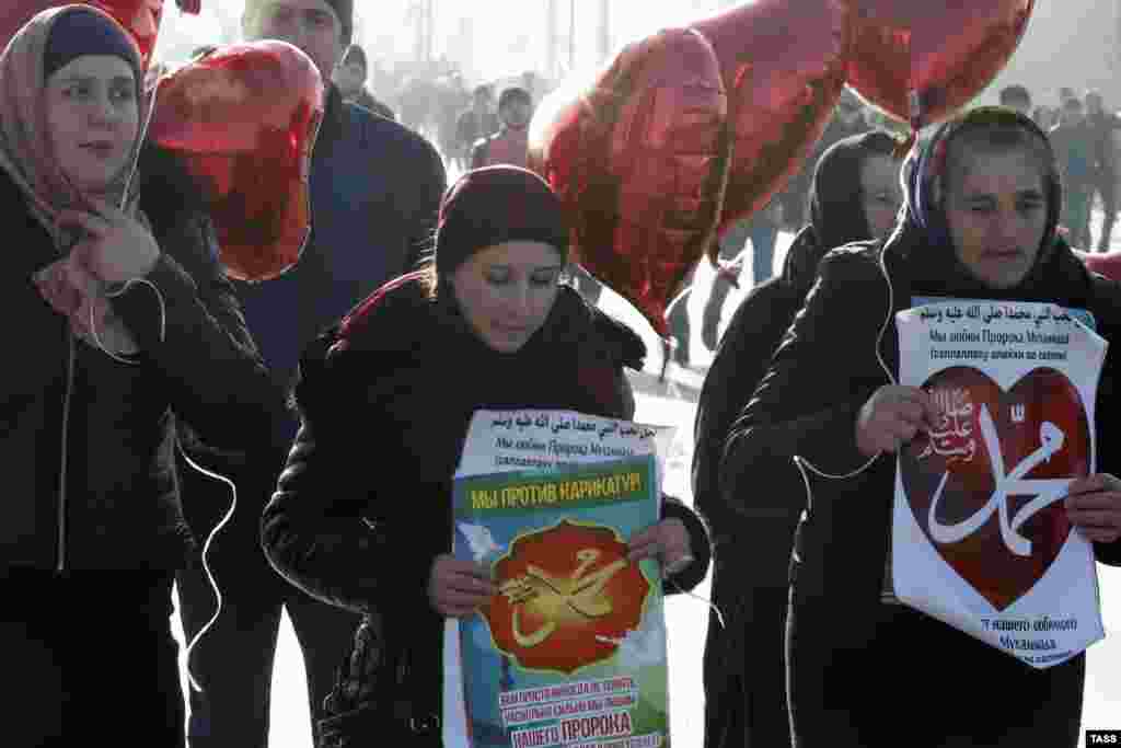The banners read "We are against caricatures" and "We love the Prophet Muhammad."