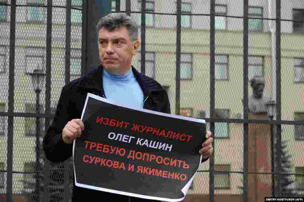 Борис Немцов держит плакат с требованием начать расследование по делу избиения оппозиционного журналиста Олега Кашина.&nbsp;