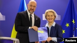 Президентка Європейської комісії Урсула фон дер Ляєн (праворуч) тримає з прем’єр-міністром України Денисом Шмигалем план для Ukraine Facility на зустрічі в штаб-квартирі ЄС у Брюсселі 20 березня 2024 року