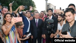 In a photo from the president's website, President Shavkat Mirziyoyev (center) poses with bloggers and journalists in Samarkand in August 2019.
