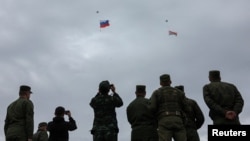 Әскери адамдар Ресей мен Беларусь туларын ұшырған дрондарға қарап тұр. Беларусьте өткен "Батыс-2025" жаттығуы. 15 қыркүйек 2025 жыл.