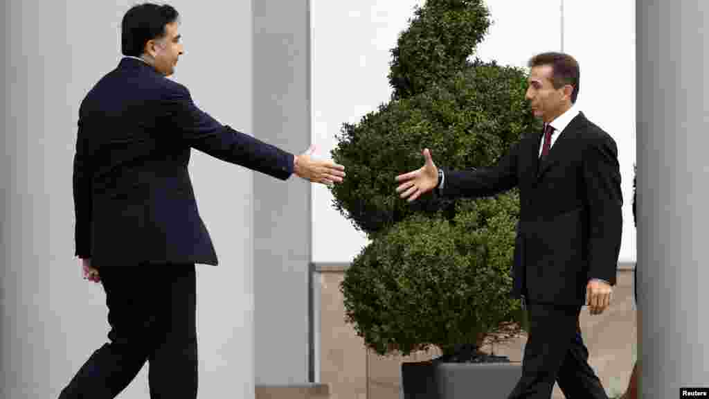 Oktyabrın 9-da Tbilisidə Gürcüstan prezidenti Mikheil Saakashvili (solda) Prezident Sarayının qarşısında Gürcü Arzusu koalisiyasının lideri və gələcək baş nazir Bidzina Ivanishvilinin əlini sıxmaq üçün yaxınlaşır.(Reuters/David Mdzinarishvili)
