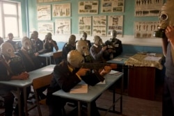 High-school students with a wooden Kalashnikov and real gas masks during a lesson in 2010