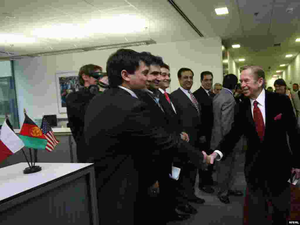 Journalists from Radio Free Afghanistan shake hands with the president.
