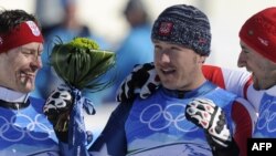 Переможець Олімпіади-2010 у Ванкувері, американський гірськолижник Боде Міллер під час квіткової церемонії (у центрі)