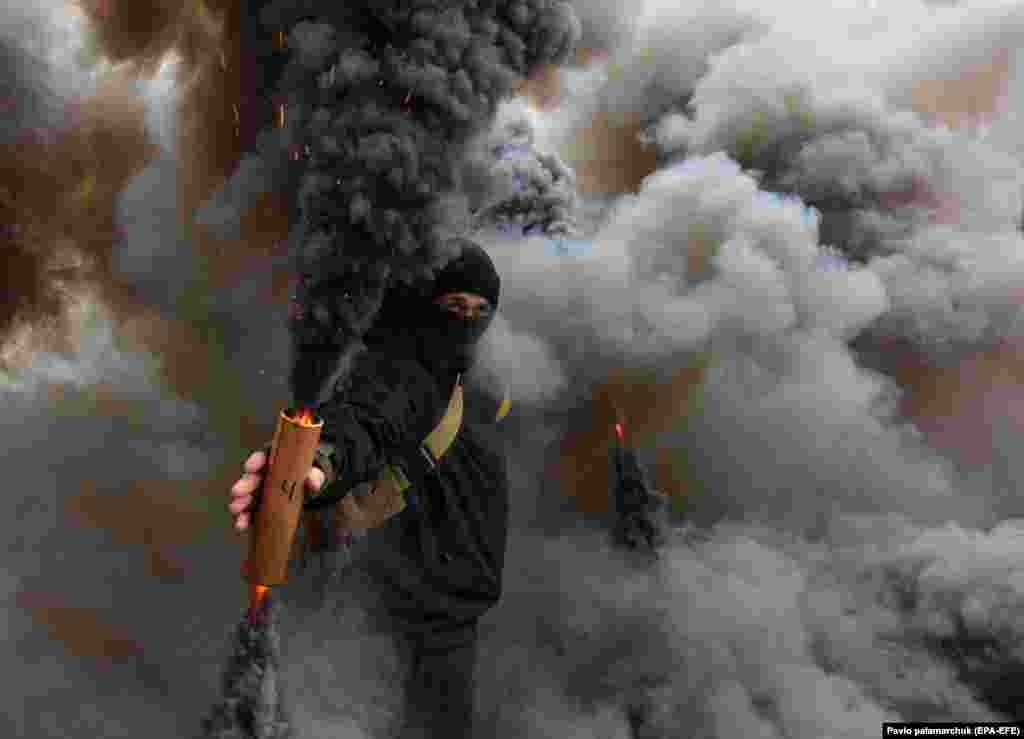 Ukrainian nationalists burn smoke grenades at a rally in downtown Lviv on December 21. (EPA/Pavlo Palamarchuk) &nbsp;